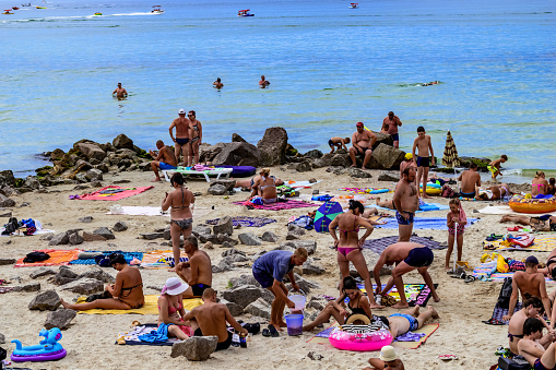 Zaliznyi Port, Ukraine - July 24, 2020: People sunbathe on blankets lying on the sand on the beach of the Zaliznyi Port (Kherson region). Summer resort vacation on the Black Sea coast