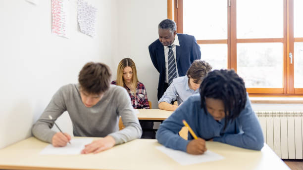 istock Male teacher supervising the class during a school exam 1330878705