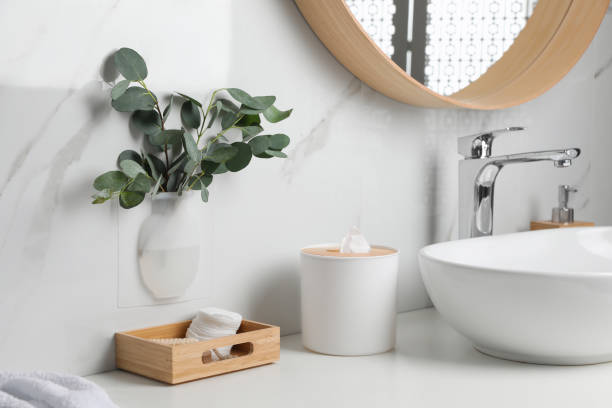 istock Silicone vase with eucalyptus branches on white marble wall over countertop in stylish bathroom 1330881464
