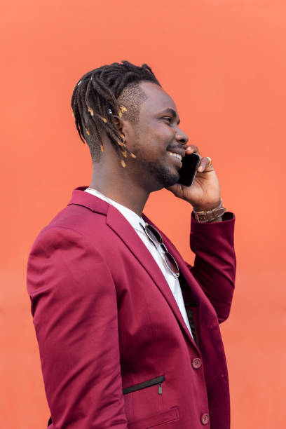 istock stylish african man smiling and talking on phone 1330882794