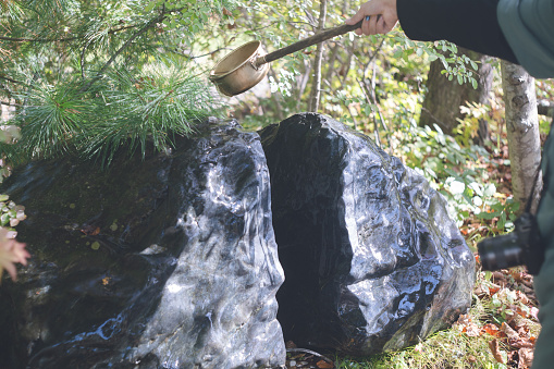 A woman sprinkles water on a matchmaking rock