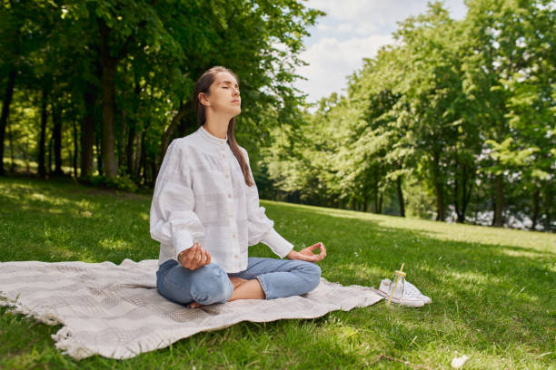 istock Young woman meditating in the park during summer 1330883442