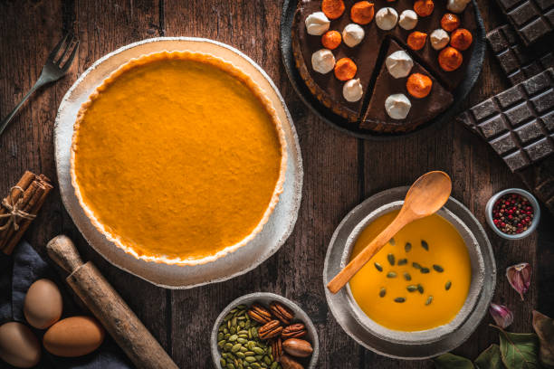Autumn pumpkin meal with pumpkin pie, butternut squash soup and pumpkin chocolate cake Autumn pumpkin meal with pumpkin pie, butternut squash soup and pumpkin chocolate cake with ingredients on wooden table squash soup stock pictures, royalty-free photos & images