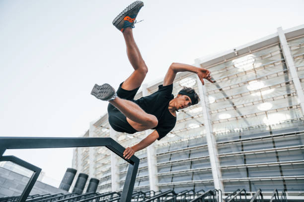 istock Does parkour. Young man in sportive clothes have workout outdoors at daytime 1330887107