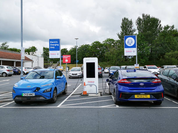 テスコ駐車場でヒュンダイioniqモーターカーを充電するポッドポイント - 英国 - tesco ストックフォトと画像