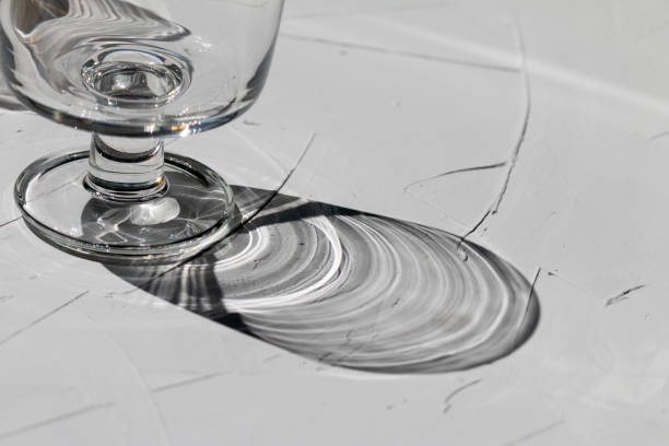 istock Glass on a grey concrete table with sunbeams and reflections 1330890469