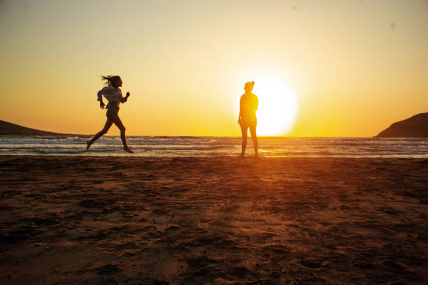 istock One silhouette on the beach runs towards the other 1330890561