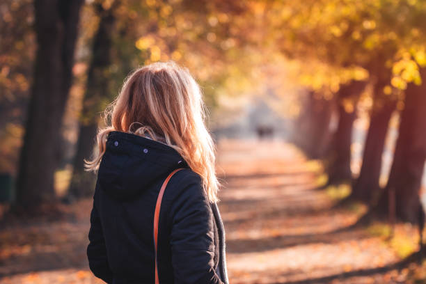 istock Woman standing in autumn park 1330890712