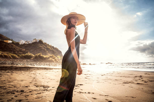 fashionable woman on a sunset walk on the beach. summer island vibes. - women hawaii islands beach beauty in nature imagens e fotografias de stock