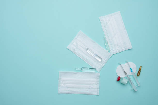 istock Syringe, mask, ampoules on a blue background, vaccination concept. 1330892798