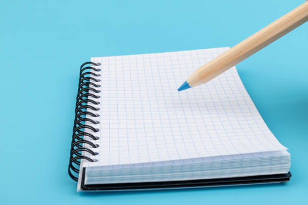 istock Blank paper and pencil on a blue background 1330892896