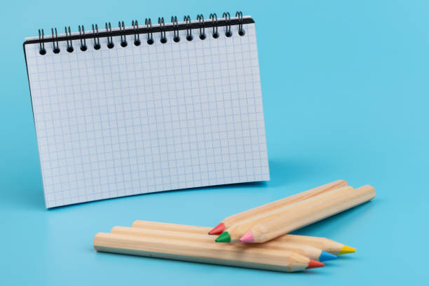 istock Blank paper and a colorful pencil on a blue background 1330892951