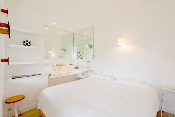 A bedroom in a luxury home with a bathtub in it
