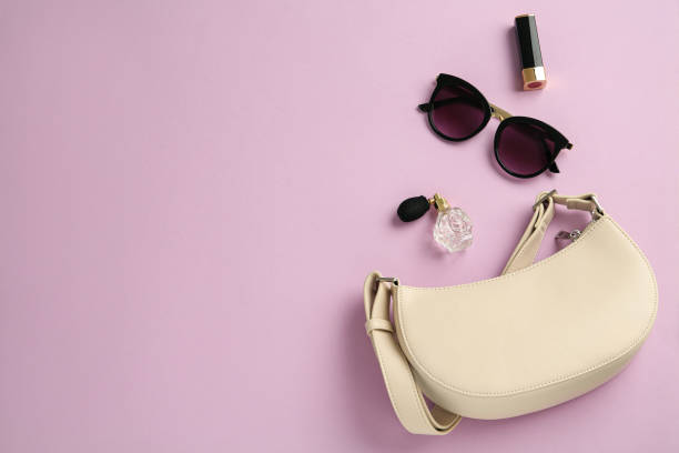 istock Flat lay composition with stylish baguette handbag on lilac background. Space for text 1330894187