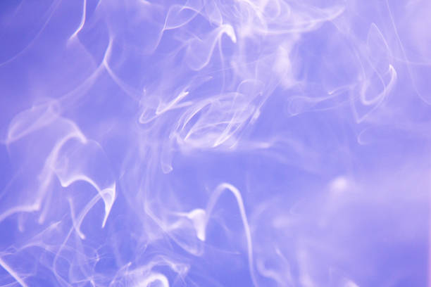 istock Puffs of white smoke on violet background 1330894256