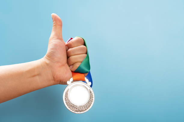 istock man lifting a silver medal with the thumb up 1330895153