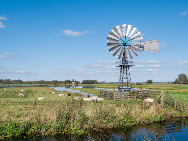moulin à eau du vent drainant le polder des zones humides, contrôle du niveau d’eau dans le parc national alde feanen, frise, pays-bas - polder windmill space landscape photos et images de collection