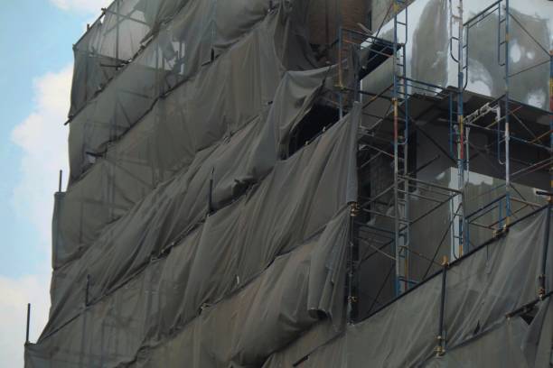 istock Construction scaffolding with gray cover at the building. 1330896494