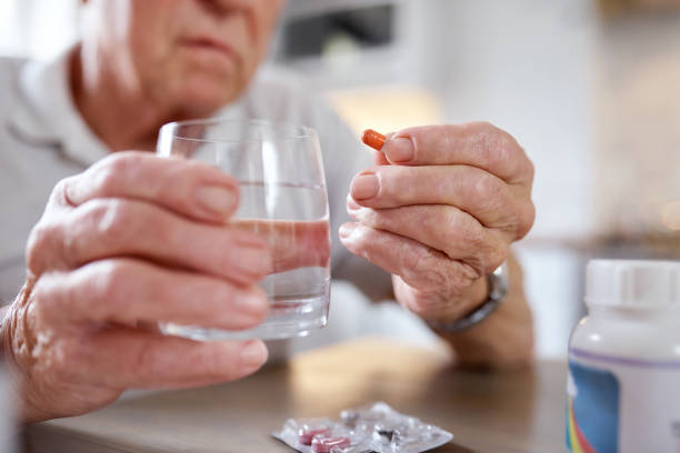 istock Closeup shot of an elderly man taking medication while siting at the kitchen table at home 1330898697