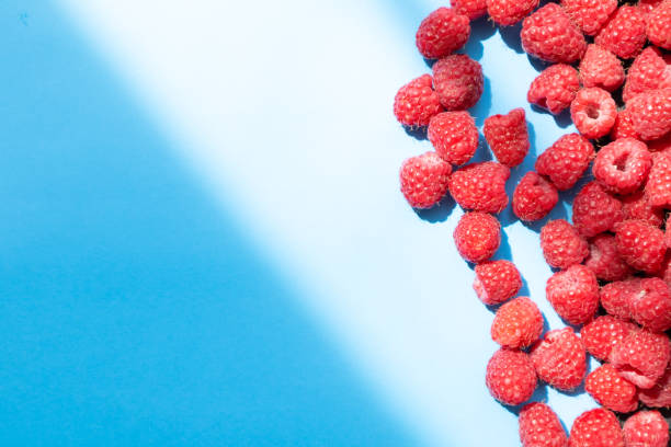 istock Fresh and sweet raspberry in a blue background. Top view 1330899655