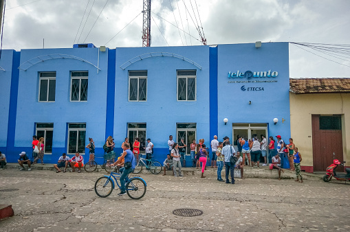 August 7, 2018 - Trinidad, Cuba: Tourists and Local Cuban People Waiting in Line at Door Entrance to Cuban Government Controlled ETECSA Telecommunication Company Office to buy internet cards