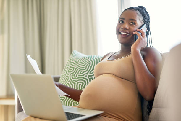 photo d’une jeune mère travaillant à domicile à l’aide de son smartphone - human pregnancy baby shower image color image photos et images de collection