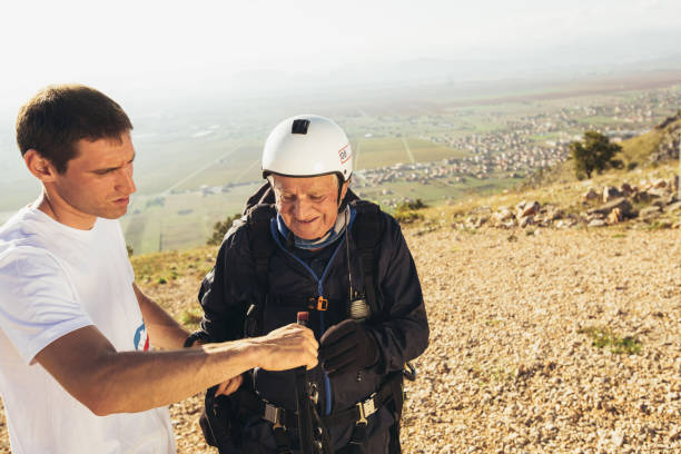 istock Active senior paraglider on the ground prepairs to fly. 1330900986
