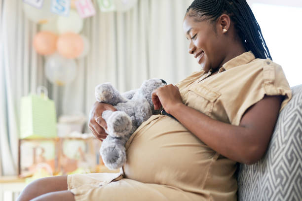 어린 어머니가 아이를 위한 부드러운 장난감을 들고 있는 장면 - one person mother cheerful women 뉴스 사진 이미지