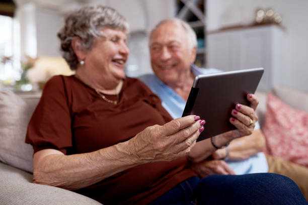 istock Shot of an elderly couple having a laugh while using a digital tablet at home 1330903832