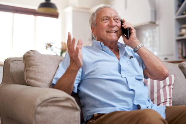 istock Shot of an elderly man on a call using his cellphone on the sofa at home 1330903857