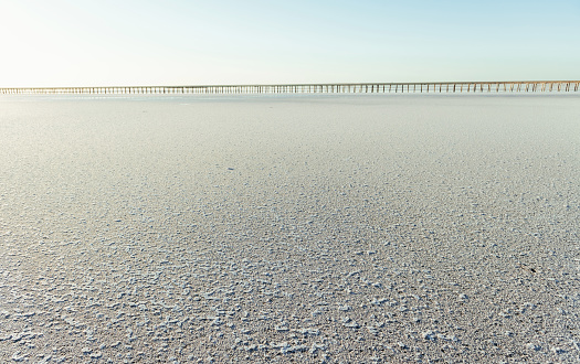 White sand on the coast. Bridge is far away at background.
