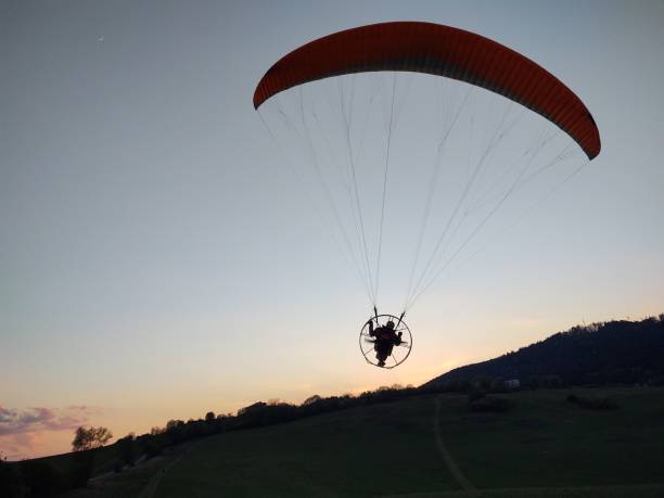 istock Paraglider flying in the air during colorful sunset. 1330905700