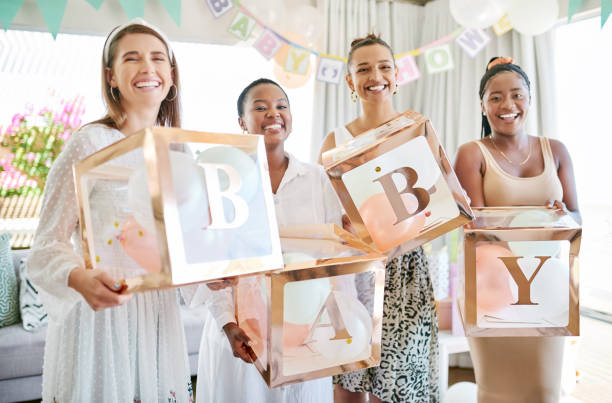 shot of a group of women holding a sign at a friends baby shower - babyshower stockfoto's en -beelden