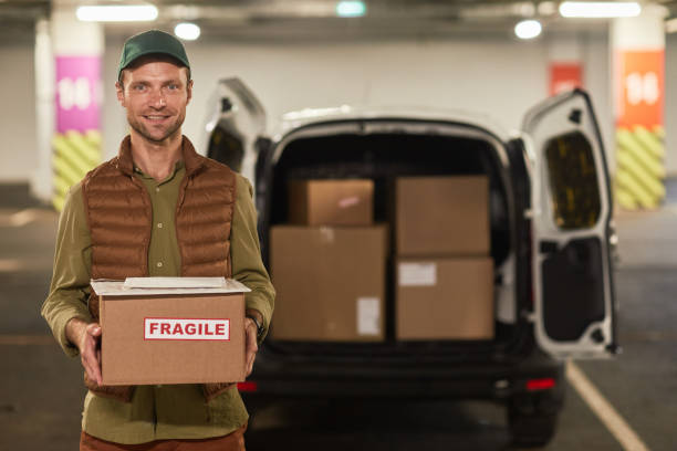 smiling delivery man mit dem van - overnight delivery stock-fotos und bilder