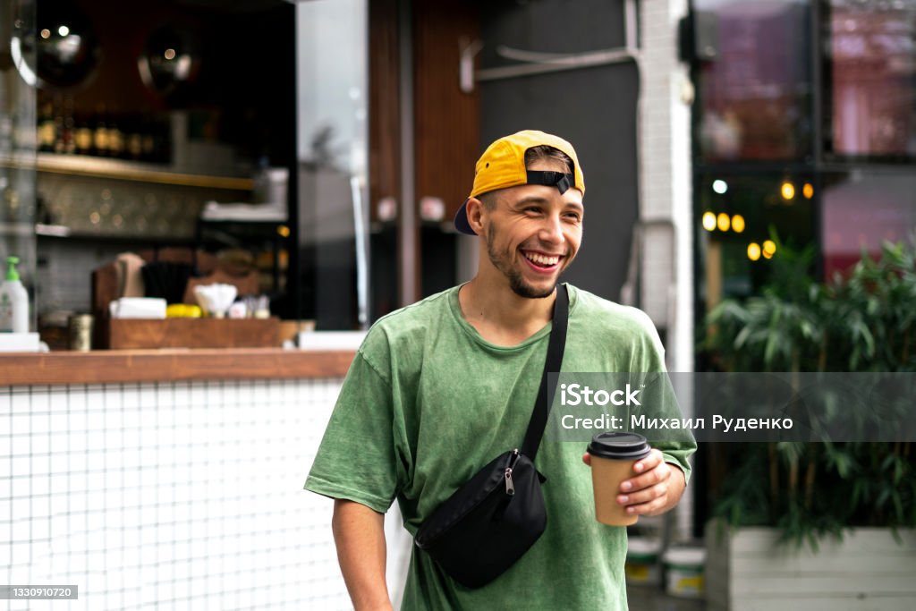 male person walking in the city street and drinking the takeaway espresso,  coffee Coffee - Drink Stock Photo