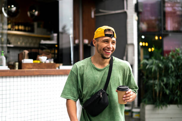 male person walking in the city street and drinking the takeaway espresso,  coffee stock photo
