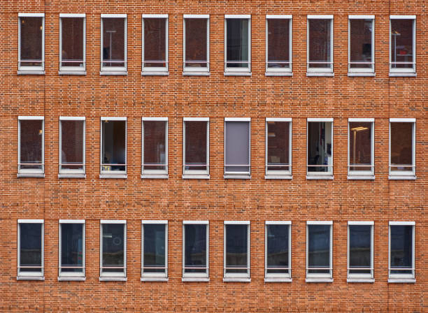 istock Monotonous facade of red bricks of a high-rise office building with long rectangular windows without curtains in the city center 1330911287