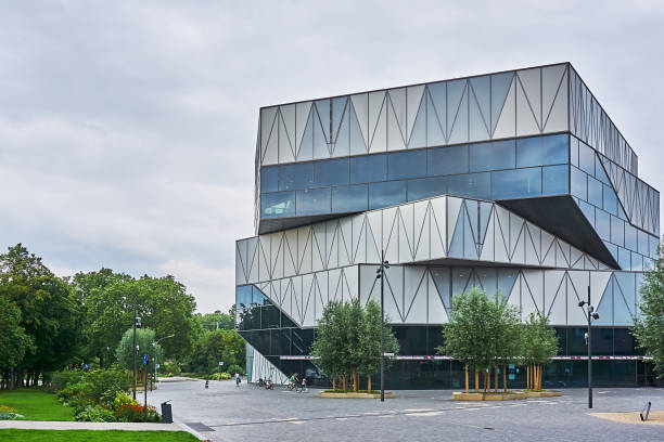 Experience Heilbronn, Germany - July 17, 2021: Pedestrians take a stroll in front of the Experimenta building. The Experimenta Science Center in Heilbronn, Baden-Württemberg. The learning and adventure world is housed in the former Hagenbucher warehouse and a new building opened in March 2019 on Kraneninsel and is intended to make science and technology accessible to people of all ages. heilbronn stock pictures, royalty-free photos & images