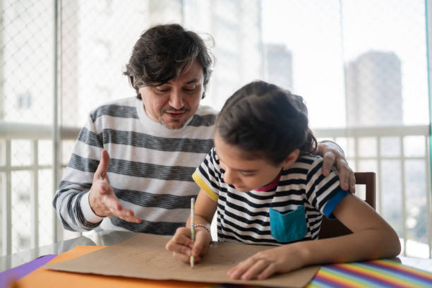 istock Father helping daughter with homework 1330915281
