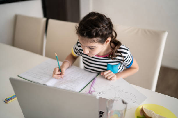 istock Girl studying using laptop at home 1330916311