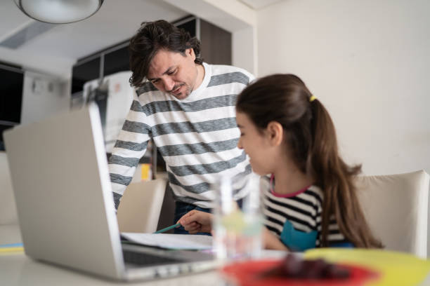 istock Father helping daughter during homeschooling 1330917378