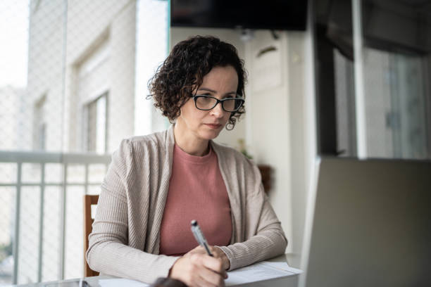 istock Mature woman using laptop working at home 1330919388