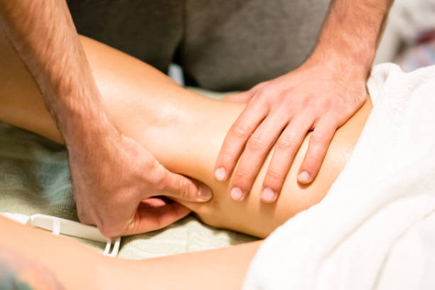 man hands giving a leg massage, alternative therapy - massage table massaging sport spa treatment imagens e fotografias de stock