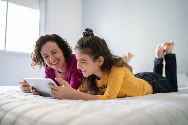 istock Mother and daughter using digital tablet at home 1330919585