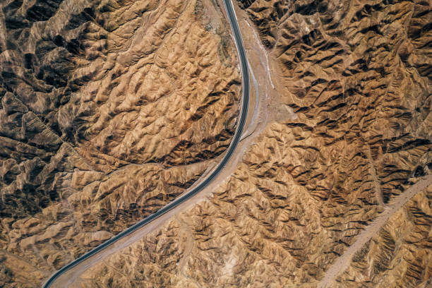 luftaufnahme der rural road durch berge und wüste - gobi desert stock-fotos und bilder