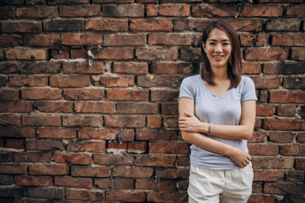 istock Japanese woman standing by a brick wall 1330921239