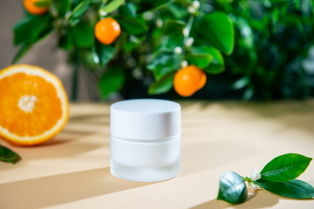 天然柑橘類のエッセンシャルオイルとみかんの木とオレンジの果物の背景と保湿フェイスクリームの閉じた瓶を閉じます。スキンケア美容製品用モックアップ。ビタミンc化粧品。スペースを - medicine closed antioxidant close to ストックフォトと画像