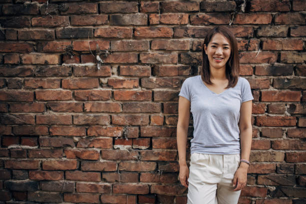 istock Japanese woman standing by a brick wall 1330921278
