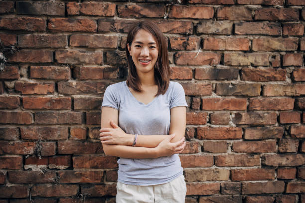istock Japanese woman standing by a brick wall 1330921298