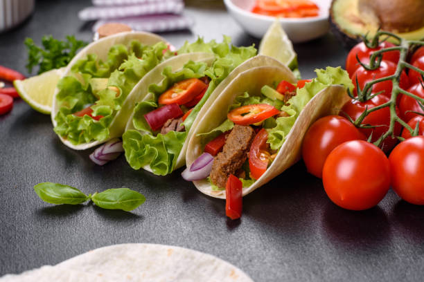 istock Mexican tacos with beef, tomatoes, avocado, onion and salsa sauce 1330924547